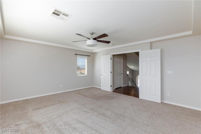 unfurnished room with visible vents, baseboards, a ceiling fan, and dark colored carpet