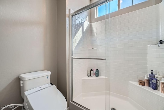 bathroom with toilet and a stall shower