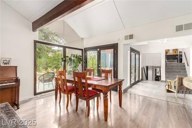 dining area with visible vents, wood finished floors, and vaulted ceiling with beams