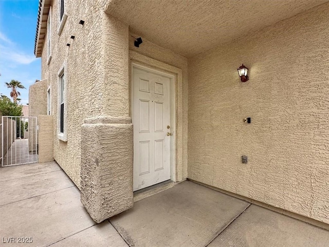 doorway to property featuring stucco siding