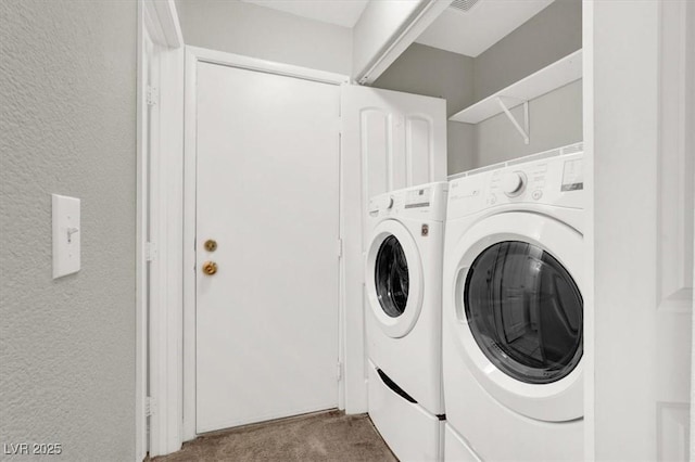 laundry area featuring laundry area, washer and dryer, carpet flooring, and a textured wall