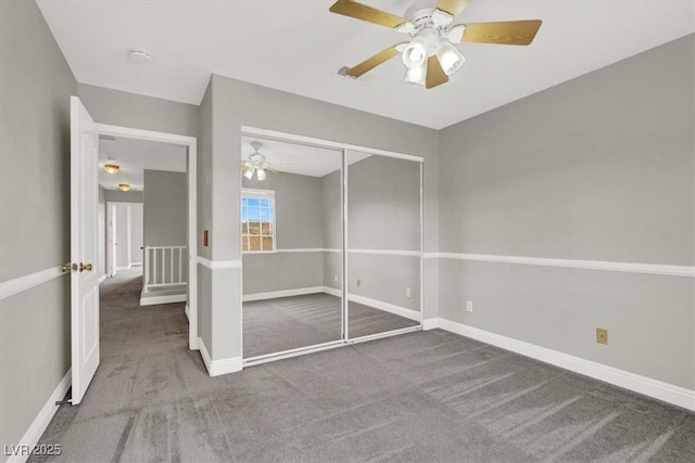 unfurnished bedroom with a closet, baseboards, carpet, and a ceiling fan