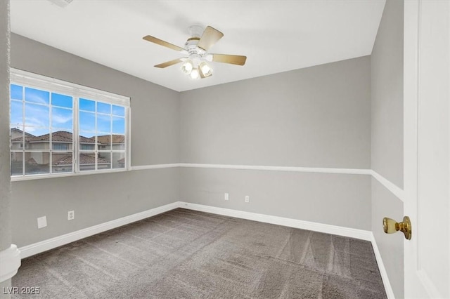 carpeted spare room featuring baseboards and ceiling fan