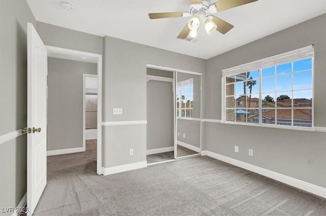 unfurnished bedroom featuring a closet, baseboards, a ceiling fan, and carpet flooring