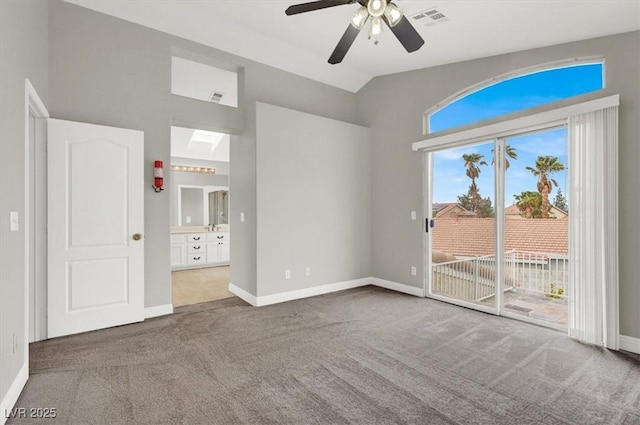 carpeted spare room featuring vaulted ceiling, baseboards, visible vents, and ceiling fan