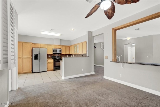 kitchen featuring light brown cabinets, ceiling fan, decorative backsplash, appliances with stainless steel finishes, and light carpet