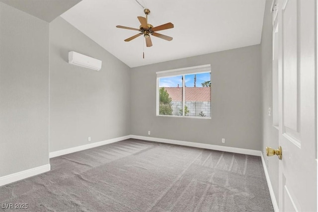 spare room with baseboards, an AC wall unit, carpet, and vaulted ceiling