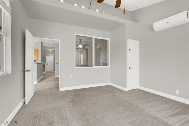 spare room featuring baseboards, an AC wall unit, a ceiling fan, and carpet floors