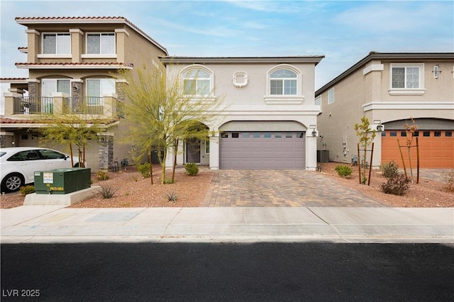 mediterranean / spanish-style home featuring stucco siding, driveway, and a garage