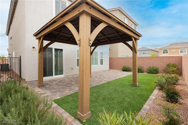 exterior space with a patio area, a gazebo, fence, and stucco siding