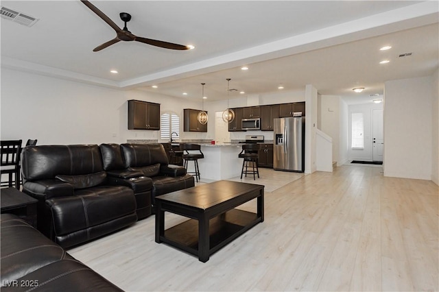 living area featuring light wood-style flooring, recessed lighting, visible vents, and ceiling fan