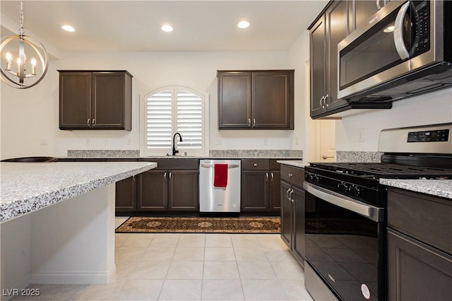 kitchen featuring dark brown cabinets, appliances with stainless steel finishes, an inviting chandelier, and a sink