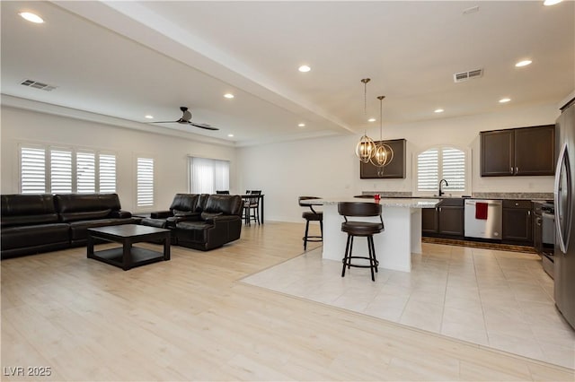 living area featuring recessed lighting, visible vents, light wood-style floors, and a chandelier