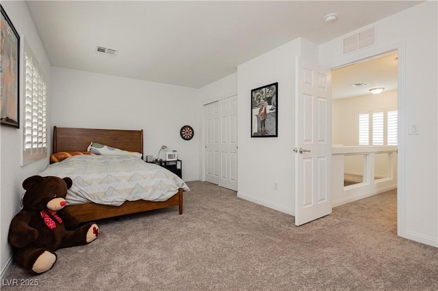 carpeted bedroom featuring visible vents, baseboards, and a closet