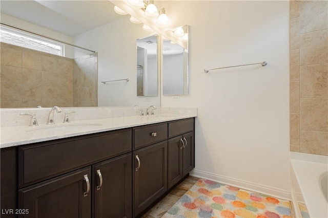 full bath featuring a sink, baseboards, a bath, and double vanity