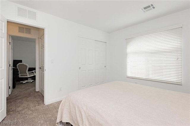 bedroom featuring visible vents, a closet, and light carpet