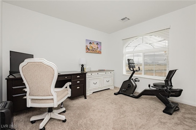 office area with visible vents, light carpet, and baseboards