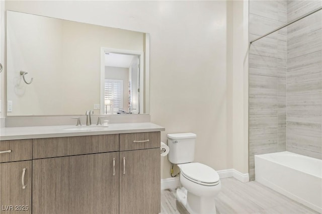 bathroom featuring baseboards, toilet, and vanity