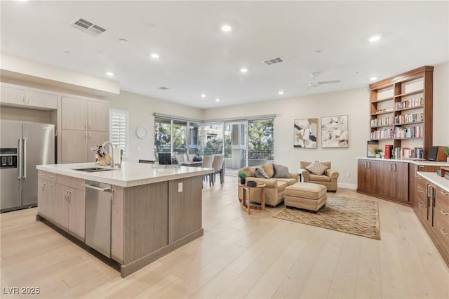 kitchen featuring visible vents, light wood-style flooring, stainless steel appliances, and light countertops