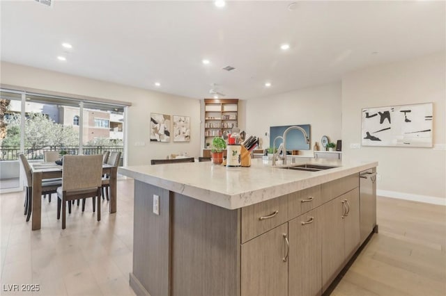 kitchen with a center island with sink, recessed lighting, a sink, dishwasher, and light wood-type flooring