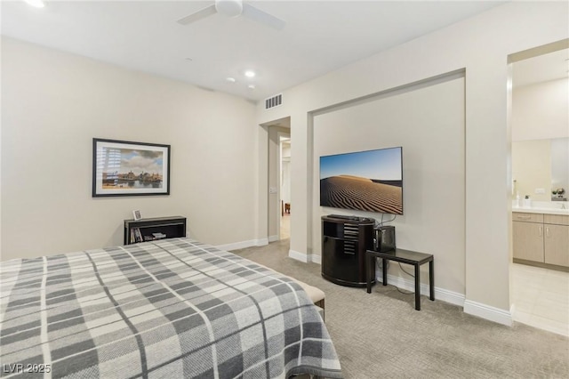 bedroom with visible vents, baseboards, light carpet, recessed lighting, and ensuite bath