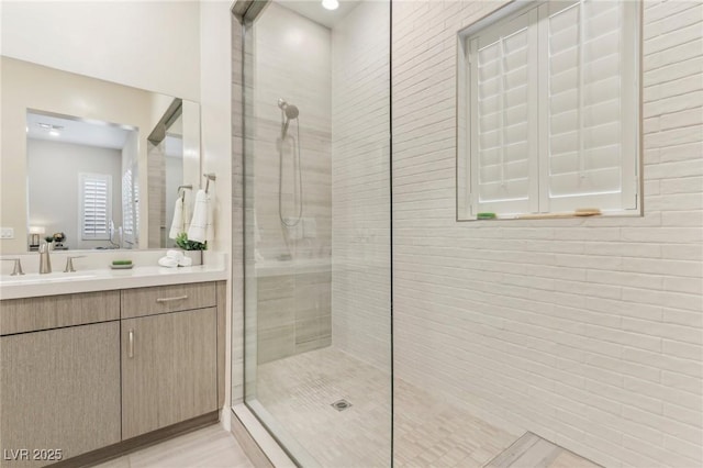 full bathroom featuring a walk in shower and vanity