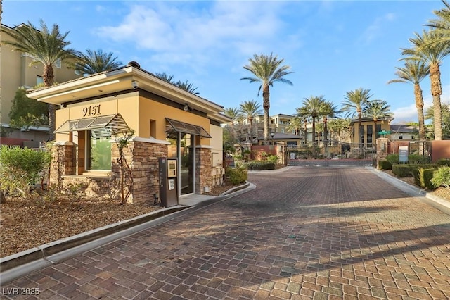 view of road with a gated entry, curbs, and a gate