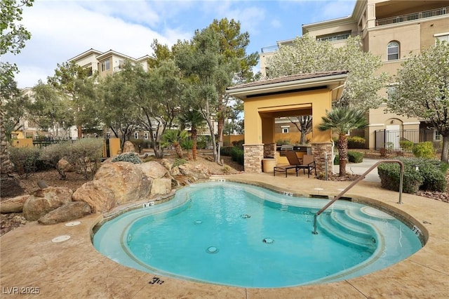 view of swimming pool with a patio and fence