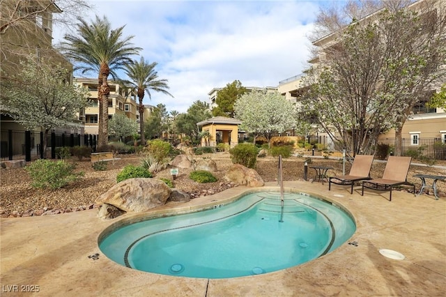 view of swimming pool featuring a patio area and fence