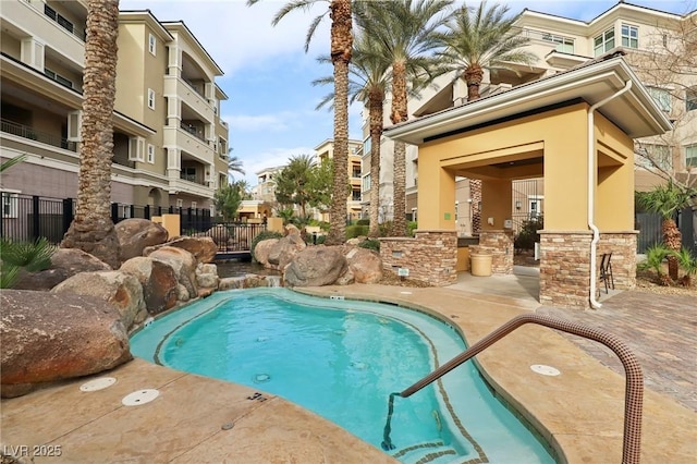 view of swimming pool featuring a swimming pool, a patio, outdoor dry bar, and fence