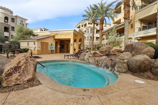 community pool with a patio and fence