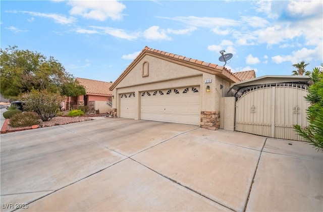 view of front of home featuring stucco siding, concrete driveway, an attached garage, and a tile roof