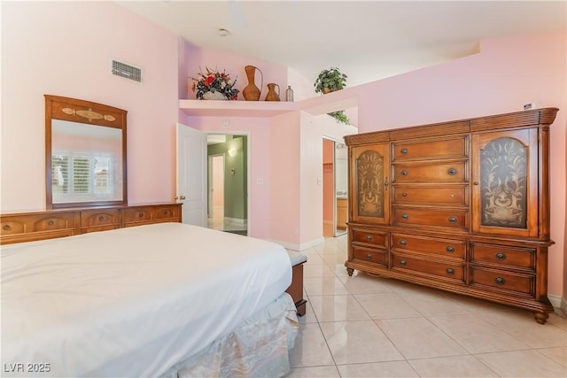 bedroom with light tile patterned floors, visible vents, and lofted ceiling