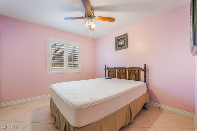 bedroom with light tile patterned flooring, a ceiling fan, and baseboards