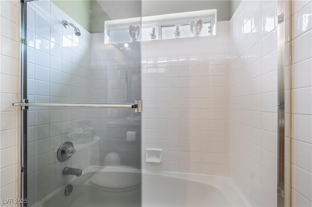 bathroom featuring enclosed tub / shower combo and toilet