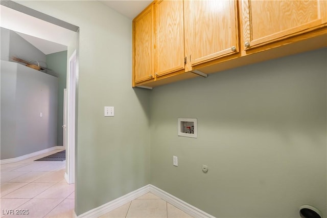 clothes washing area featuring baseboards, cabinet space, washer hookup, and light tile patterned flooring