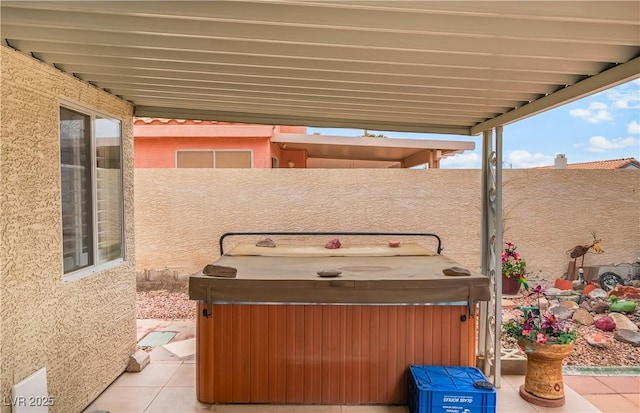 view of patio / terrace featuring a hot tub and fence