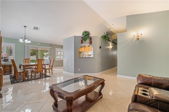 living area with visible vents, baseboards, a notable chandelier, and light tile patterned flooring