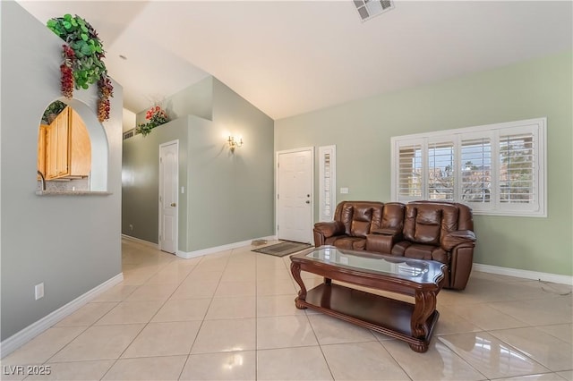 living area with visible vents, lofted ceiling, baseboards, and light tile patterned flooring