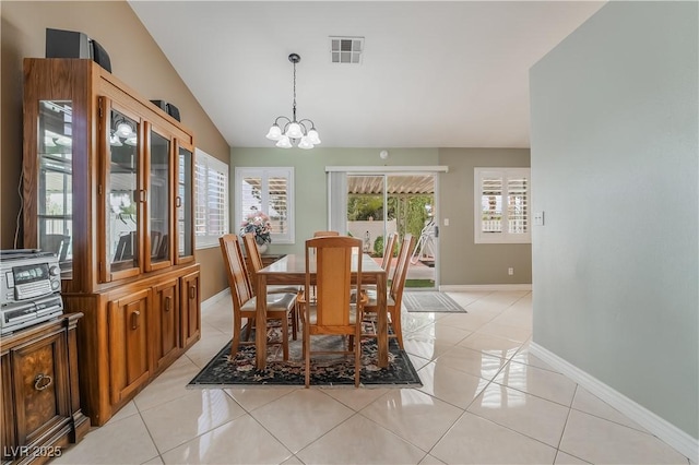 dining space with lofted ceiling, light tile patterned flooring, visible vents, and a chandelier