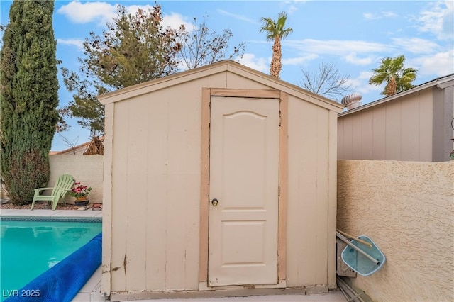 view of shed with a fenced in pool and fence