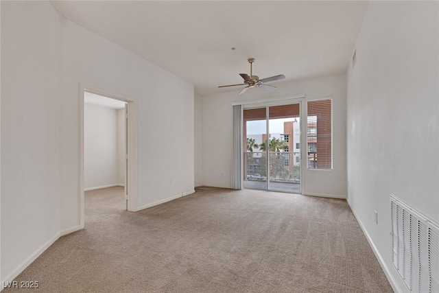 carpeted empty room featuring visible vents, baseboards, and a ceiling fan