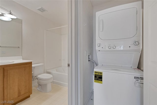 clothes washing area featuring visible vents, laundry area, and stacked washer / dryer