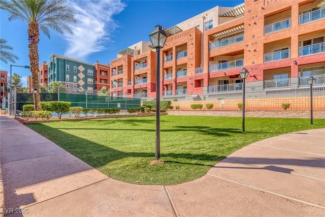 view of community with a yard and fence