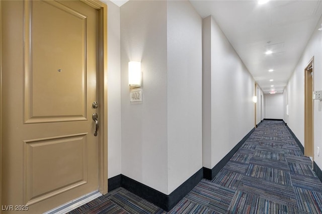 hallway with recessed lighting, baseboards, and dark colored carpet