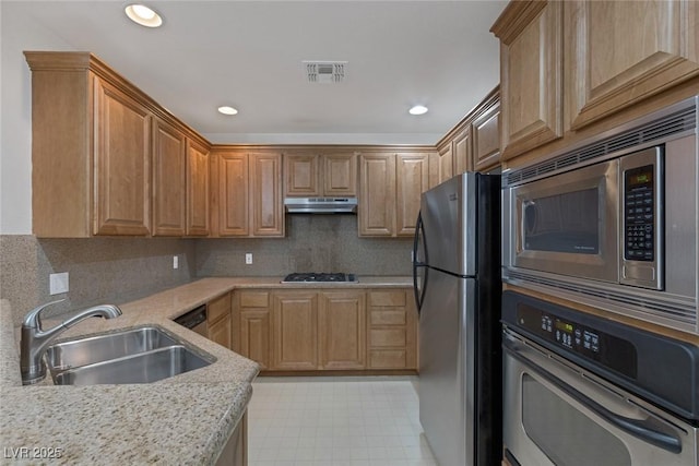 kitchen with visible vents, under cabinet range hood, a sink, tasteful backsplash, and stainless steel appliances