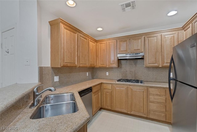 kitchen featuring visible vents, a sink, stainless steel appliances, under cabinet range hood, and backsplash