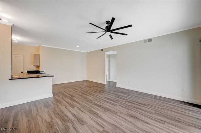 unfurnished living room featuring visible vents, baseboards, wood finished floors, and a ceiling fan