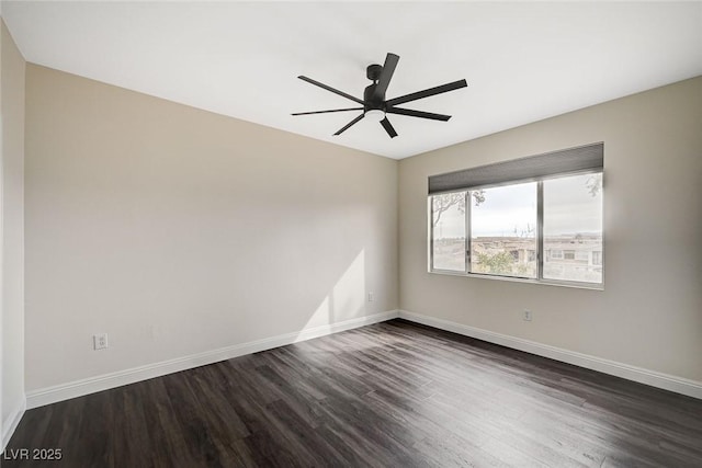 empty room featuring a ceiling fan, dark wood-style floors, and baseboards