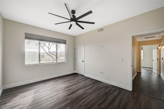 unfurnished bedroom with dark wood-type flooring, baseboards, visible vents, and ceiling fan